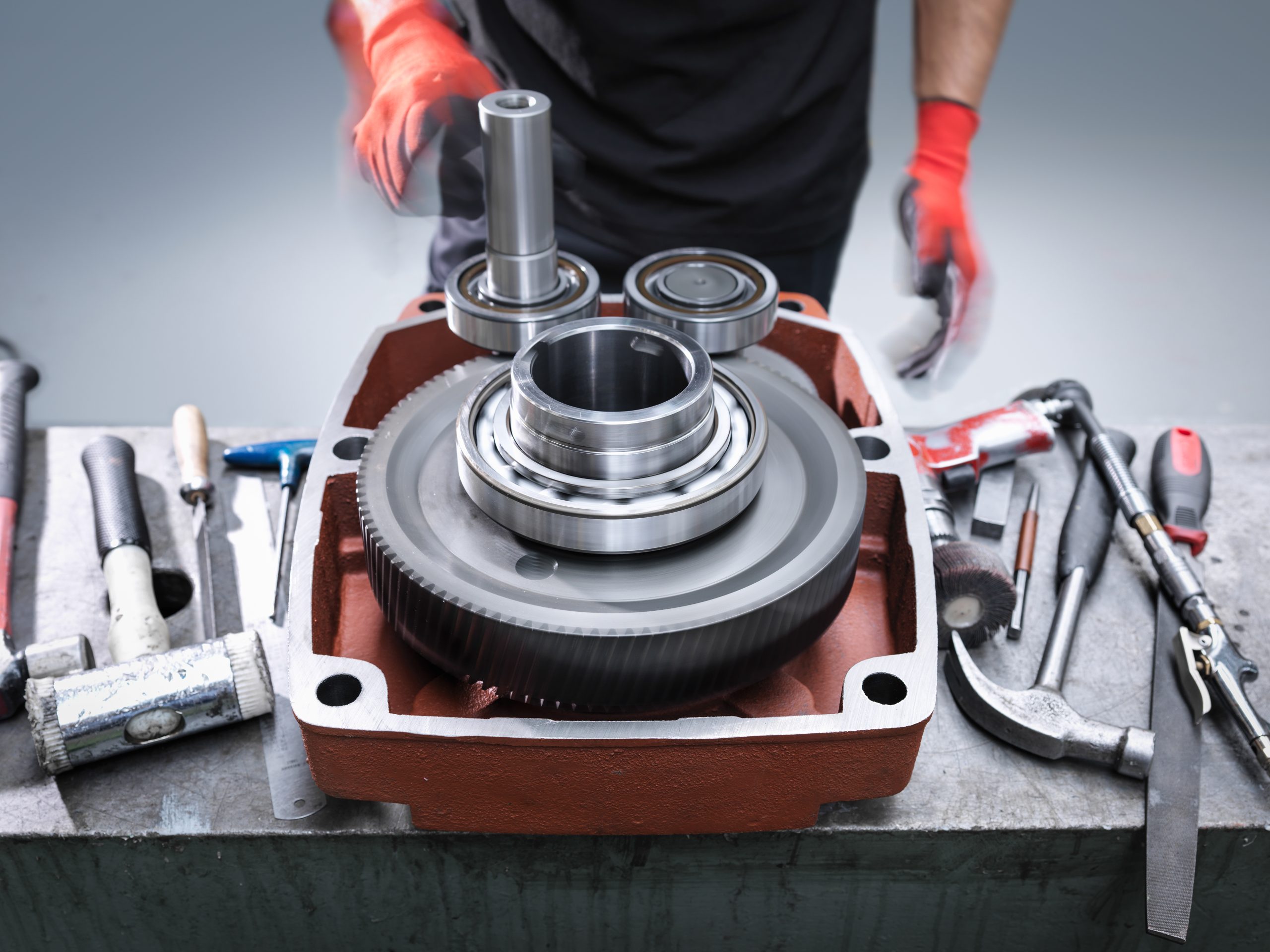 engineer assembling industrial gearbox in engineering factory close up - Avigauto Recambios